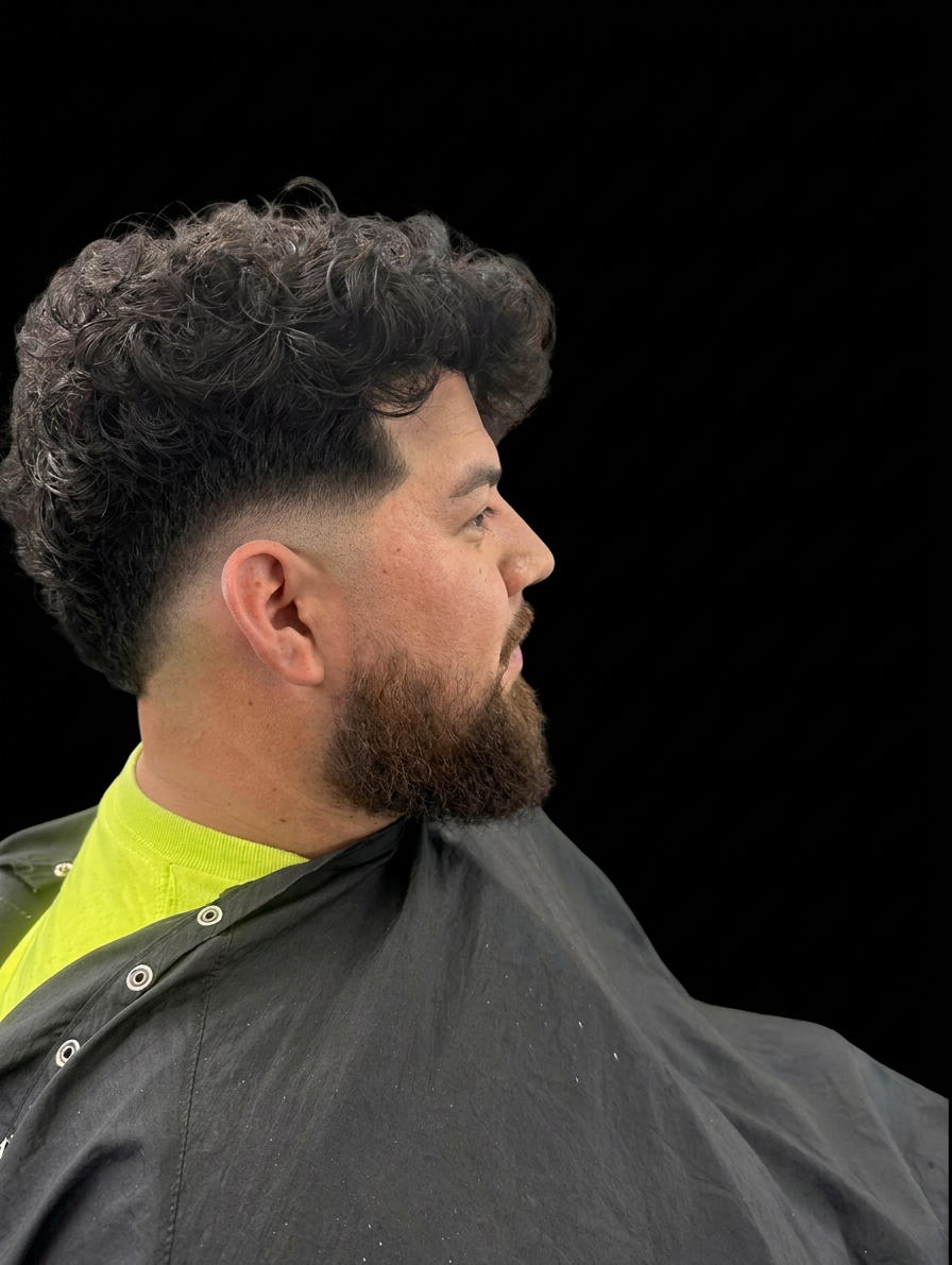 Curly top with low skin fade and beard blend